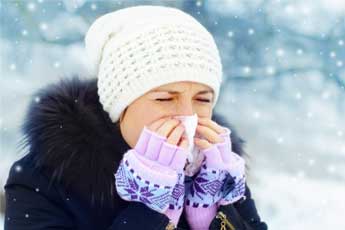 Una ragazza che si soffia il naso a causa di un'allergia invernale